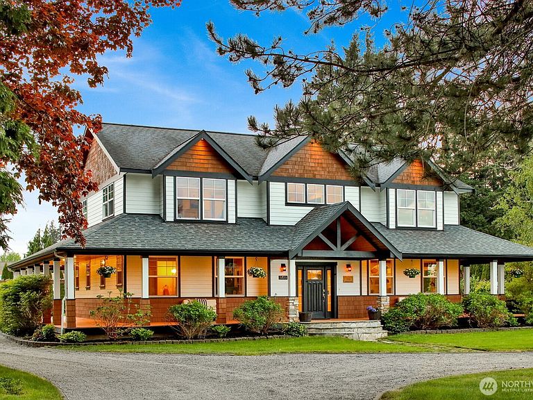 Front elevation of the craftsman estate in midday Pacific Northwest light, framed by a Japanese maple and cedars.